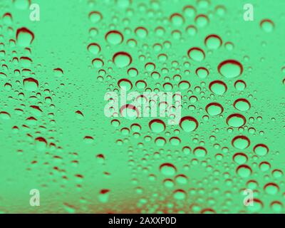 Ein makro-textures Foto von Wasser fällt auf Glas, das grün getönt ist Stockfoto