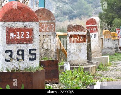 Alte Meilensteine, die auf der Straße Bailen-Motril (N-323) bei der Durchfahrt durch La Cerradura de Pegalajar (Jaen-Spanien) aufgedeckt wurden Stockfoto