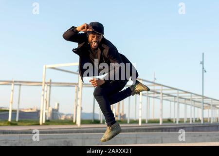 Junge Tänzerin in modischer schwarzer Kleidung tanzt blake an einem Herbstnachmittag auf einer Straße in der Stadt. Lifestyle. Stockfoto