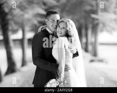 Brautpaar umarmte zärtlich beim Fotografieren im Park. Stockfoto