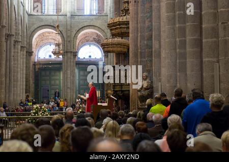 Ein Priester leitet die traditionelle Pilgermesse an der Kathedrale in Santiago de Compostela, Spanien. Oben schwebend ist der Botafumeiro, das berühmte Silber Stockfoto