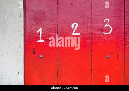 Der Eingang eines Ladens ist mit rot lackierten Holztafeln verschlossen, die mit weißen Nummern versehen sind. Sie ist häufig auf den Philippinen, in Asien zu sehen. Stockfoto