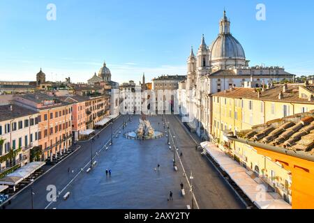 Blick vom frühen Morgen von einer Terrasse auf die Piazza Navona, während das Sonnenlicht die Kuppel auf der Kathedrale St. Agnes in Rom, Italien, beleuchtet Stockfoto