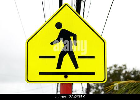 Nahaufnahme einer hellen, gelben Straßenbeschilderung auf dem quadratischen Gehweg, die gegen einen bewölkten Himmel fotografiert wurde, zu sehen auf den Philippinen, Asien Stockfoto