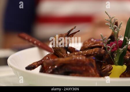 Peking-/Roast-Entengericht wird in einem chinesischen Restaurant serviert. Der Entenkopf ist das fokussierte Thema im restlichen Körper des gesamten Gerichts. Stockfoto