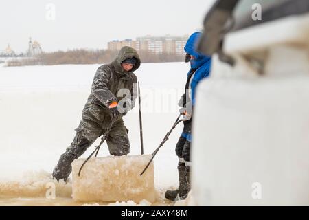 Der Monteur mit Stahlzange zieht den Eisblock heraus Stockfoto