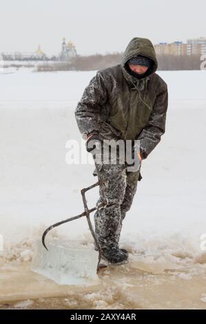 Der Monteur mit Stahlzange zieht den Eisblock heraus Stockfoto