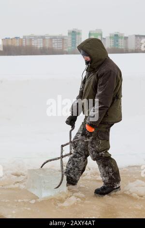 Der Monteur mit Stahlzange zieht den Eisblock heraus Stockfoto