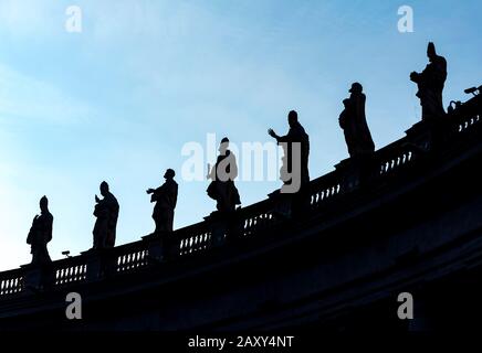 Silhouetten von Statuen von Heiligen auf Bernini-Kolonnaden, Petersplatz, Vatikan, Rom, Italien Stockfoto