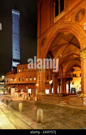 Asinelli-Turm, beleuchtet in der Abenddämmerung im Vordergrund Arcade, Bologna, Emilia-Romagna, Italien Stockfoto