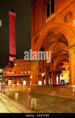 Asinelli-Turm, beleuchtet in der Abenddämmerung im Vordergrund Arcade, Bologna, Emilia-Romagna, Italien Stockfoto