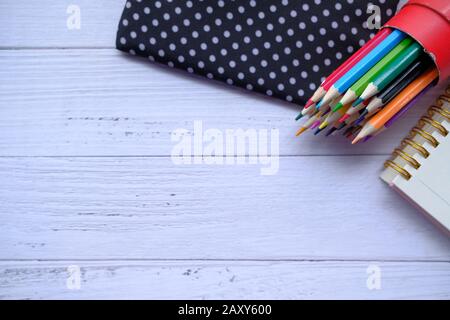 Draufsicht über Farbstifte und Notizblock auf dem Tisch Stockfoto