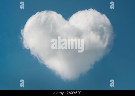 Herzförmige Wolke am blauen Himmel mit Raum für Text, Valentinstag Hintergrund. Stockfoto