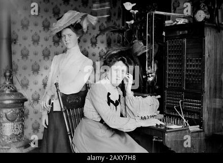 Zwei Frauen posieren mit einer frühen Telefonzentrale in den USA, ca. 1900. Stockfoto