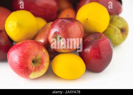 Obstsortiment auf weißem Hintergrund. Äpfel, Birnen, Zitronen und Mandarinen schließen sich an Stockfoto