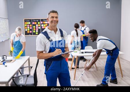 Hausmeister mit seinem Team Reinigung modernes Büro Stockfoto