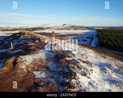 Ein Tourist guy Spaziergänge in der Nähe Kerid See im Winter in Island. Unglaubliche Winterlandschaft von Island. Stockfoto