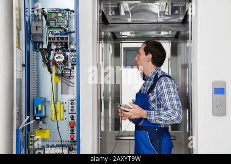 Techniker Reparieren Bedienfeld Des Defekten Elevators Stockfoto