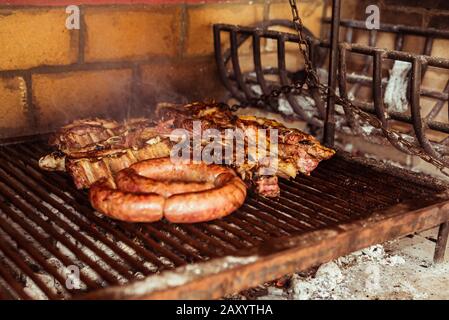 "Argentinischen Grill' Grill auf live Coal (keine Flamme), Rindfleisch "Asado", Brot, "Chorizo" und Blutwurst bin orcilla' Stockfoto