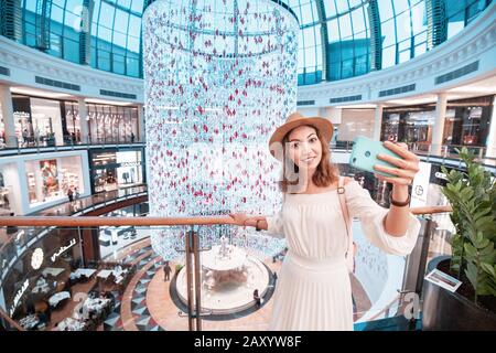 27. November 2019, VAE, Dubai: Junges Touristenmädchen, das selfie-fotos in einem der größten Einkaufszentren in Dubai - Emirates Mall gemacht hat Stockfoto