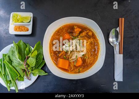 Köstliche vietnamesische, gedämpfte Reis-Nudeln mit Rinderbrasse auf schwarzem Hintergrund Stockfoto