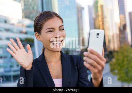 Business Meeting Konzept für Video-Chat. Geschäftsfrau nimmt selfie Foto mit der Smartphone-App auf dem Smartphone für soziale Medien lächelnd fröhliche Anzugjacke im Freien. Urbaner weiblicher Profi. Stockfoto