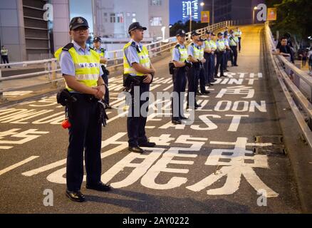 Hongkong, China: 16. Juni 2019. Polizist legt sich die Hand auf eine Dose Pfefferspray, bereit, sollte ein Protestler außer Dienst treten.Demonstranten marschieren durch Wan Stockfoto