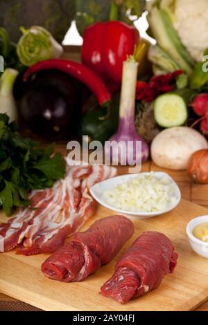 Zwei rohe Kalbseskalope und verschiedene Zutaten Stockfoto