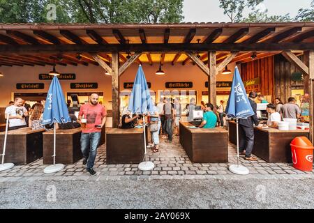 August 2019, München, Deutschland: Menschen ruhen und trinken im Biergarten Stockfoto