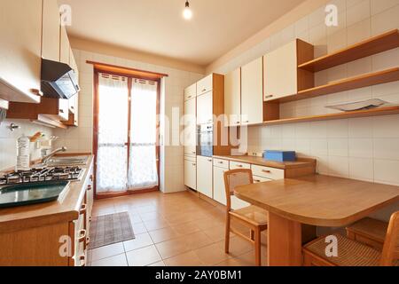 Kücheneinrichtung mit Holztisch an einem sonnigen Tag in normaler Wohnung Stockfoto