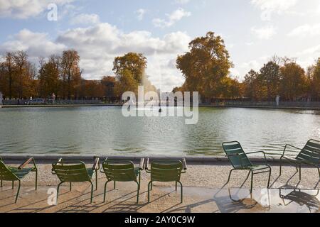 Paris - 7. NOVEMBER 2019: Tuileries Garten mit grünen Stühlen und Springbrunnen, sonniger Herbst in Paris Stockfoto