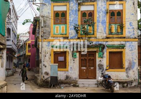 DIU, Indien - Dezember 2018: Ein altes, verblichenes Haus mit farbig bemalten Rechteckfenstern auf den Straßen der Insel Diu. Stockfoto