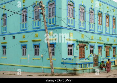 DIU, Indien - Dezember 2018: Ein altes, helles türkisgrünes Haus mit altmodischen, bunten Fenstern in den Straßen der Inselstadt Diu. Stockfoto