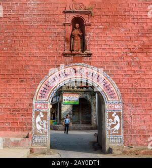 DIU, Indien - Dezember 2018: Die alten, roten Wände und schönen Wandbilder auf dem Bogen der Kolonialzeitarchitektur des Zampa-Torways. Stockfoto