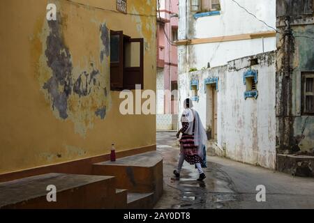 DIU, Indien - Dezember 2018: Eine Frau spaziert in den ruhigen, engen Gassen der Stadt Diu. Stockfoto