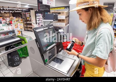 23. Juli 2019, Auchan Supermarket, Lyon, Frankreich: Girl-Kunde scannt Produkte an der Selbstbedienungskasse im Supermarkt Stockfoto
