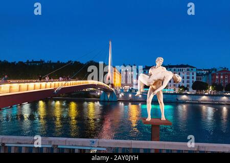 23. Juli 2019, Lyon, Frankreich: Zwei Männerstatuen, die sich Selbst das Gewicht nennen, an einem Ufer des Flusses Saone in der Abendzeit Stockfoto