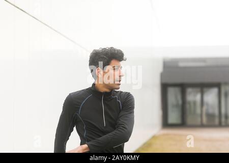 Porträt eines Joggers, der im Freien steht und sich aufwärmt, Deutschland Stockfoto