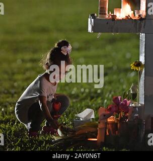 PARKLAND, FL - 16. Februar: Eine junge Frauen Orte Blumen an einer Gedenkstätte, ehrt die Opfer der Masse schießen auf Marjory Stoneman Douglas High School, At Pine Trail Park am 16. Februar in Parkland, Florida 2018. Polizei verhaftet 19-jährigen ehemaligen Schüler Nikolas Cruz für die Ermordung von 17 Personen an der High School. Personen: Atmosphäre Stockfoto