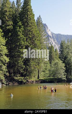 Touristen, die im Merced River im Yosemite National Park, Kalifo, baden Stockfoto