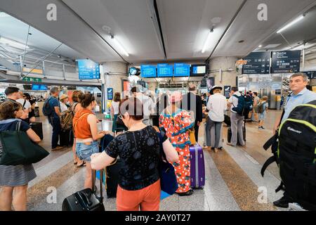 24. Juli 2019, Lyon, Frankreich: Die Leute, die in der Wartehalle in der Nähe von Fahrplanmonitoren im Bahnhof auf den Zug warten Stockfoto