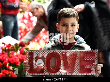 Damaskus, Syrien. Februar 2020. Ein Junge hält ein Geschenk zum Valentinstag auf einem Marktplatz in der Altstadt von Damaskus, Syrien, 13. Februar 2020. Mehrere Geschäfte begannen hier anlässlich des Valentinstages mit dem Verkauf von roten Teddybären und herzförmigen Souvenirs. Kredit: Ammar Safarjalani/Xinhua/Alamy Live News Stockfoto