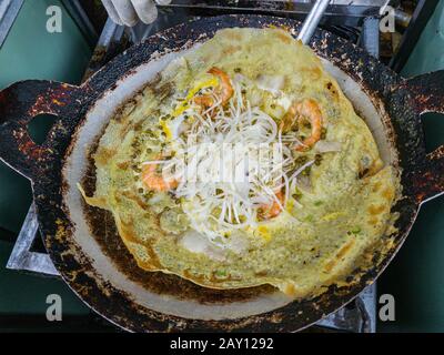 Sizzling vietnamesische Krustenpfannkuchen mit Garnelen und Gemüse - Banh Xeo Stockfoto