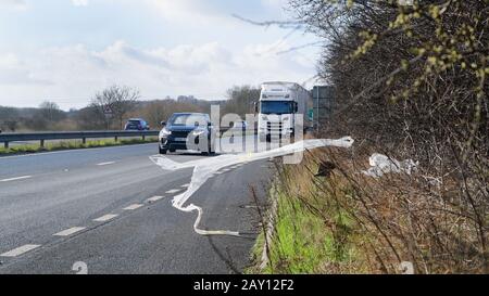 Der Verkehr, der vorbeifuhr, warf Plastikmüll in Layby auf EINEM 64, der im Wind leeds united Kingdom wehte Stockfoto