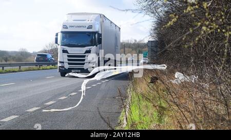 Der Verkehr, der vorbeifuhr, warf Plastikmüll in Layby auf EINEM 64, der im Wind leeds united Kingdom wehte Stockfoto