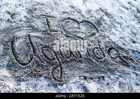 Fingerabdruck auf dem Sand an der Küste des Victoriasees "Ich liebe Uganda" und das Herz Stockfoto