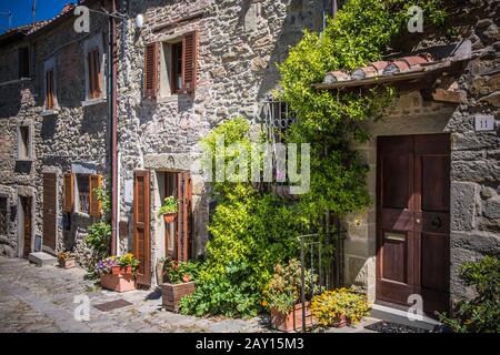 Toskana Straße im Frühling / Schmale Straße der italienischen Kleinstadt Cortona mit Steinhäusern Stockfoto