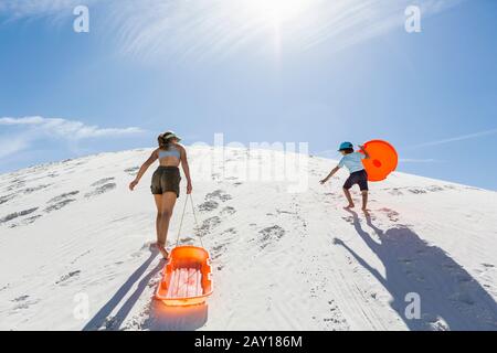 Geschwister klettern auf Sanddüne Stockfoto