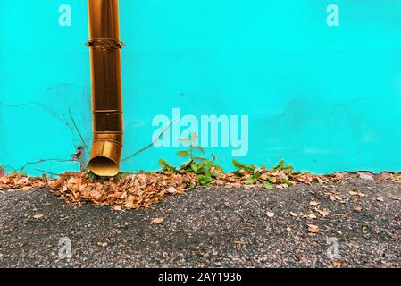 Eine große blaue Wasserversorgungsleitung mit Absperrhahn gegen eine gelbe Betonwand. Stockfoto