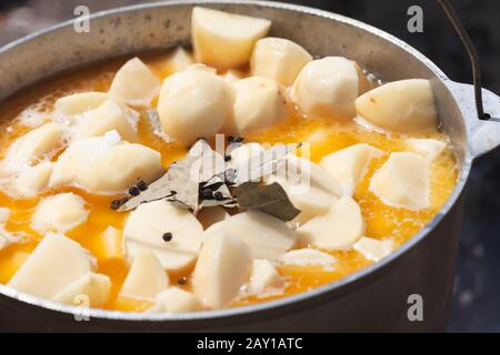 Pikante Touristensuppe mit Kartoffelkohlen in einem Kessel. Vorbereitung auf ein offenes Feuer, Campingmenü Stockfoto